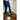 Shoes stand with ice cleats on green mat, on wooden floor near white wall.