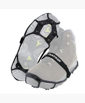 View of Yaktrax Spikes, attached to pair of hiking boots with one upright and the other upside down